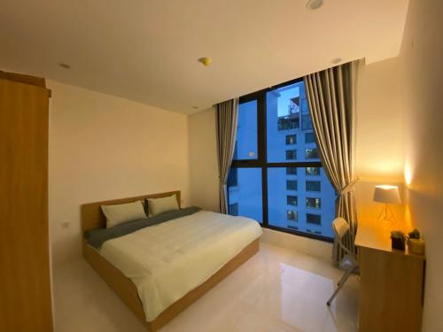 a bedroom with a bed and a large window at Housinco Premium - Serviced Apartments Nguyễn Xiển Street near Tops Market in Hanoi