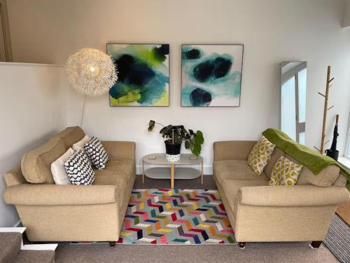 a living room with two couches and a rug at Barn conversion, Old Hatfield, Herts Just a few minutes walk to Hatfield train station and Hatfield House in Hatfield
