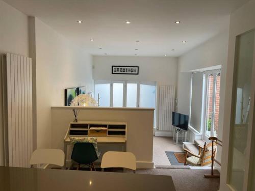 Barn conversion, Old Hatfield, Herts Just a few minutes walk to Hatfield train station and Hatfield House في هاتفيلد: غرفة معيشة مع مكتب وكراسي