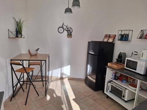 La cuisine est équipée d'un réfrigérateur, d'une table et d'un four micro-ondes. dans l'établissement Appartement Stockholm, à Gap