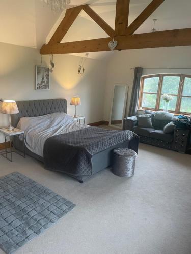 um quarto com uma cama grande e um sofá em Dairy farm em Crewe