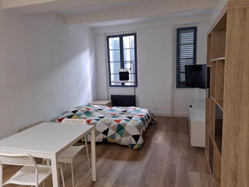 une chambre avec un lit et une table dans une pièce dans l'établissement 182, studio proche opéra, à Toulon