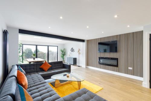 a living room with a couch and a tv at Free Parking Stylish & modern 4-bedroom home with sea views in Brighton & Hove