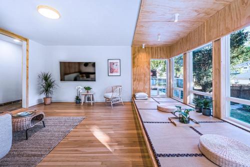 a living room with wooden floors and windows at Three-Tree Villa-Central Location in Vancouver