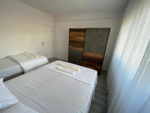 Un dormitorio pequeño con dos camas y una ventana. en Best Apartament PR, en Pristina