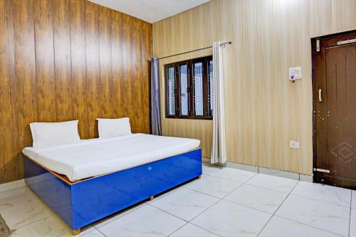 Posto letto in camera con parete in legno. di OYO Hotel The Selaqui Paradise a Jhājra