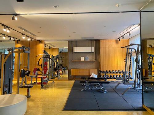 a gym with treadmills and machines in a room at 1BR ~ The Charming Branz by lalerooms CLOSE TO ICE in Samporo