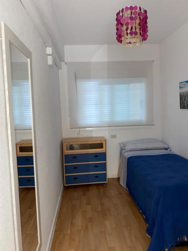 - une chambre avec un lit bleu et un miroir dans l'établissement Sea & Mountain Views Benicassim, à Benicàssim