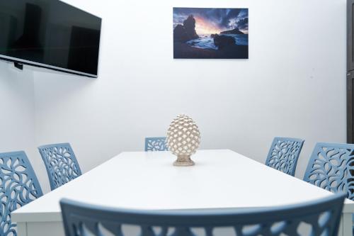 a white table with chairs and a vase on it at La Maison Apparthotel in Praia a Mare