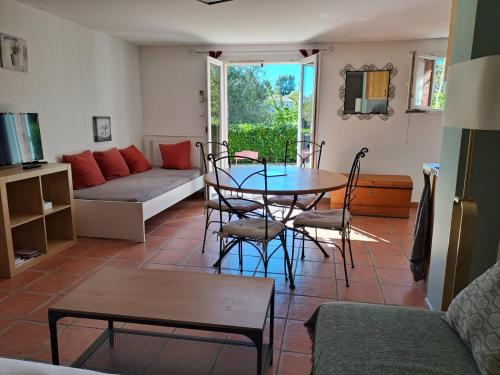 a living room with a table and chairs and a couch at Studio Escale champêtre 31 in Donneville