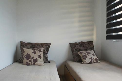two beds in a room with two pillows at Dino's apartment in Skopje