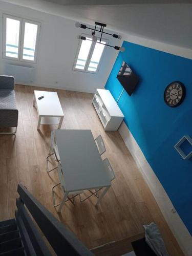un salon avec une table blanche et un mur bleu dans l'établissement 185, Toulon petit duplex a deux pas de l'Opéra, à Toulon