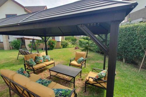a patio umbrella with chairs and a table in a yard at Aspen Luxury Villa in Accra
