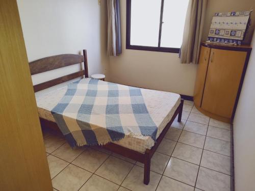 a small bedroom with a bed and a window at Edifício Thiago Augusto in Guarapari