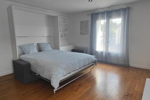 a bedroom with a bed and a large window at Guest house indépendante in Bombon