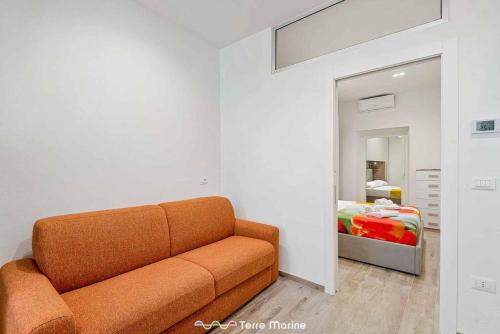 an orange couch in a room with a bed at XX di Mare, Terre Marine in Monterosso al Mare