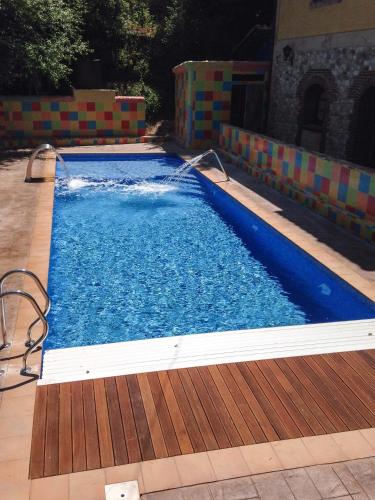 ein großer blauer Swimmingpool mit Holzterrasse in der Unterkunft Hotel Trapa in Soto de Cangas