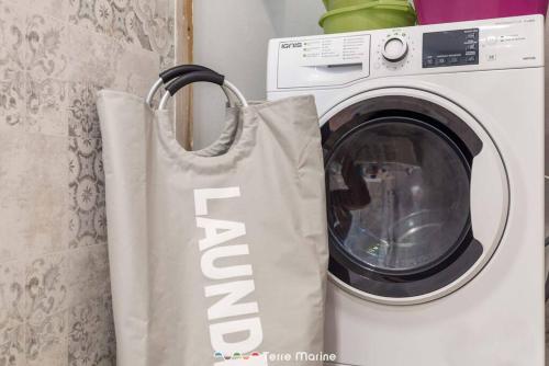 a tote bag hanging next to a washing machine at XX di Mare, Terre Marine in Monterosso al Mare