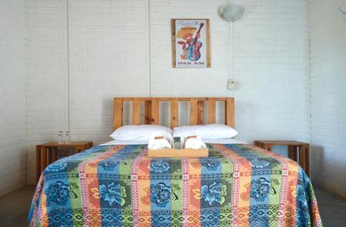 a bedroom with a bed with two shoes on it at Playa del Ritmo Beach Hostel & Bar - Adults Only in Santa Marta