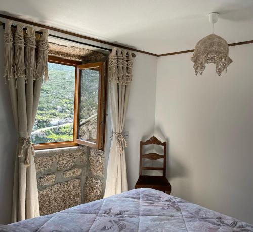 een slaapkamer met een bed en een raam bij Casa Pinhão in Sabugueiro