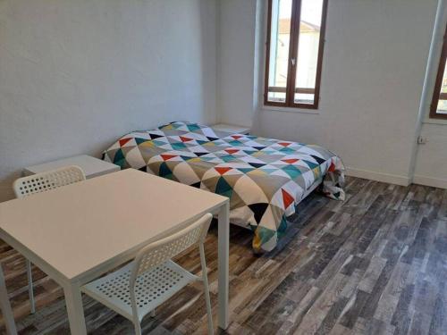 une chambre avec un lit, une table et des chaises dans l'établissement BudgetBnb 282, studio centre-ville, à La Seyne-sur-Mer