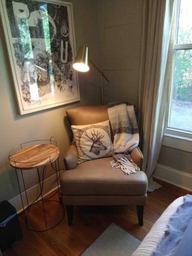 a living room with a chair and a table at Gingerbird Art Suite in Laurel