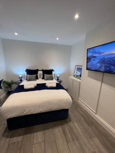 um quarto com uma cama grande e uma televisão de ecrã plano em Windsor Apartment em Brighton & Hove