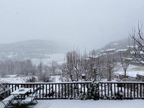 a snow covered yard with a fence and trees at Idílico refugio de montaña ideal escapadas in Olopte