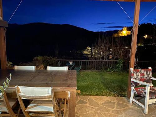 a wooden table and chairs on a patio at night at Idílico refugio de montaña ideal escapadas in Olopte