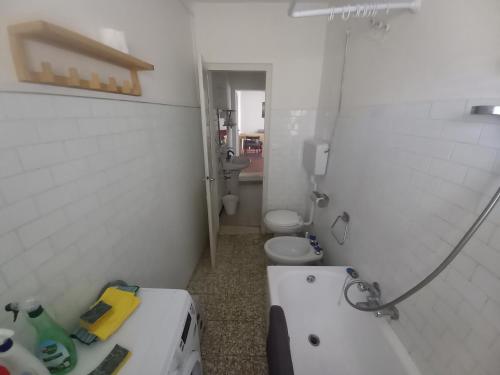 y baño con 2 aseos, lavamanos y bañera. en Console Camprini Rooms & Apartments - Naviglio, en Faenza