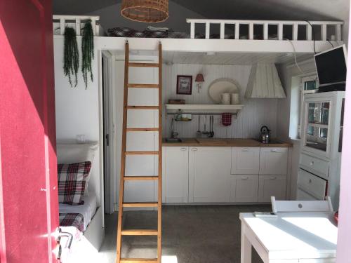 a room with a bunk bed with a ladder and a kitchen at Lisbon Cozy House w/Garden and Pool in Valejas