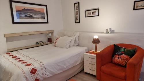a bedroom with a bed and a chair at Studio Bay View in Cape Town