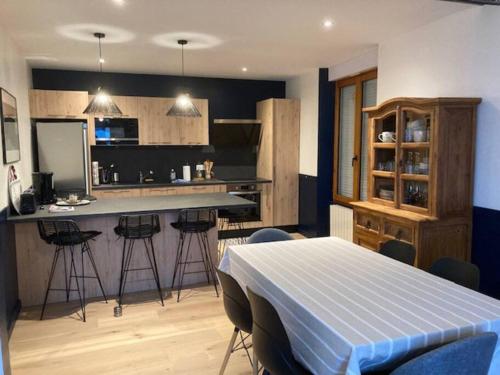 une cuisine avec une table et un bar avec des tabourets dans l'établissement Appartement 3p 70m2, vue mer, plage et port de Lomener, à Ploemeur