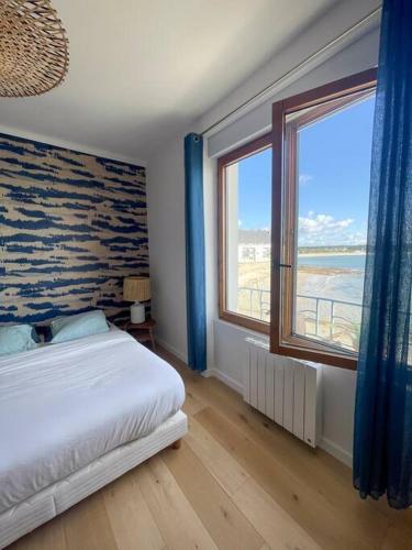 une chambre avec un lit et une grande fenêtre dans l'établissement Appartement 3p 70m2, vue mer, plage et port de Lomener, à Ploemeur