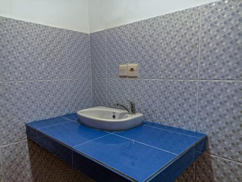 lavabo en un mostrador azul en el baño en Black Sweet Bungalow, en Gili Air