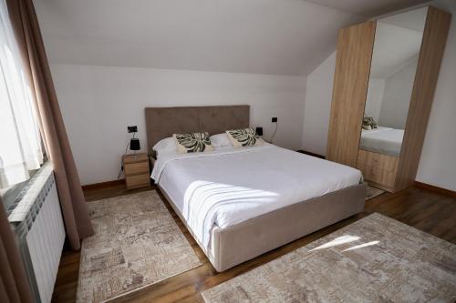een slaapkamer met een groot bed en een spiegel bij Comfy House in Borşa