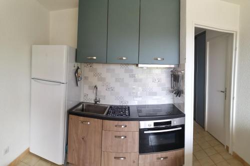 La cuisine est équipée d'une cuisinière, d'un évier et d'un réfrigérateur. dans l'établissement Appartement T2 + cabine - classé 3 étoiles, à Bormes-les-Mimosas