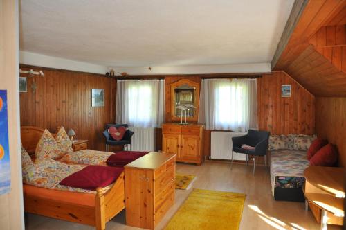 a living room with a bed and a couch and a table at Villa Waldfriede in Gnesau
