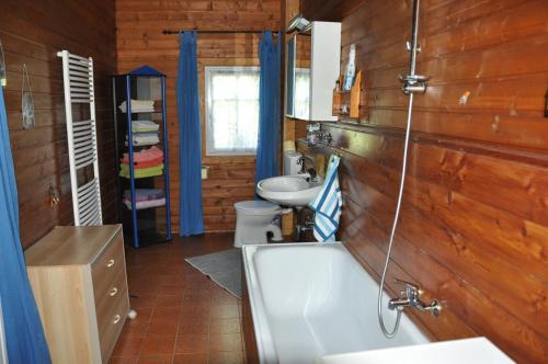 a bathroom with a tub and a sink and a toilet at Villa Waldfriede in Gnesau