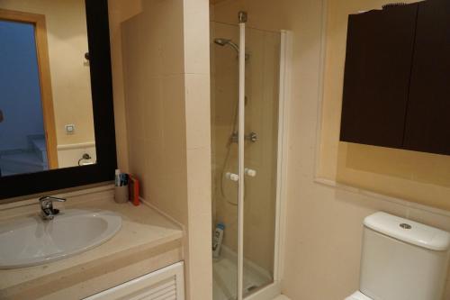a bathroom with a shower and a sink and a toilet at Adosado de lujo en El Portil Playa y Golf in El Portil
