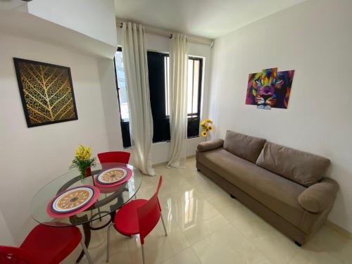sala de estar con sofá, mesa y sillas en Apartamento Vilage na Praia de Armação Salvador, en Salvador