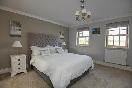 Un dormitorio con una cama grande y una lámpara de araña. en Sunset View at The Dovecote en Kirkby on Bain