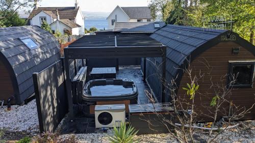 a dog house with a chair and a couch under it at Beach House Pods in Dunoon