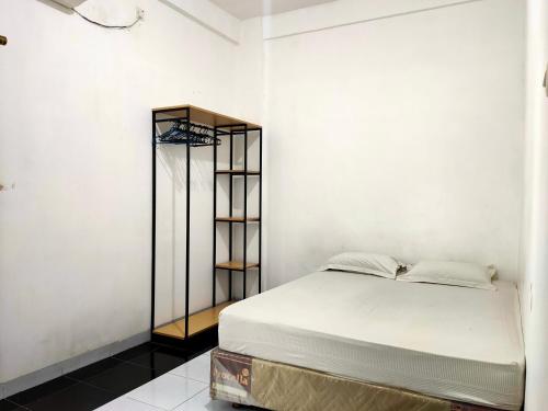 ein Schlafzimmer mit einem Bett und einem schwarzen Bücherregal in der Unterkunft OYO 93122 Pondok Puti Sartika Syariah in Banjarmasin