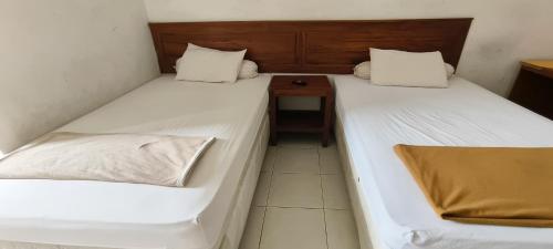 Ένα ή περισσότερα κρεβάτια σε δωμάτιο στο Hotel O Wisma Hamalau SyariahNearPulau Bromo Pedestrian Bridge