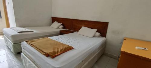 Ένα ή περισσότερα κρεβάτια σε δωμάτιο στο Hotel O Wisma Hamalau SyariahNearPulau Bromo Pedestrian Bridge