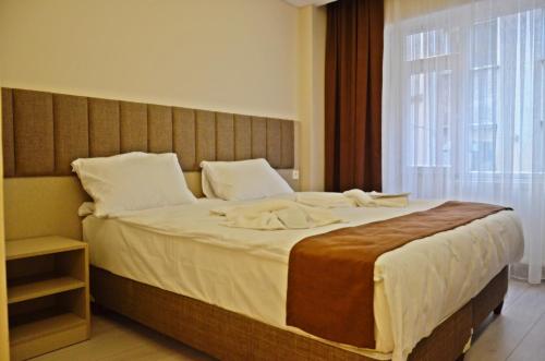 a bedroom with a large bed with a large window at Yesilirmak Aparts Hotel in Istanbul