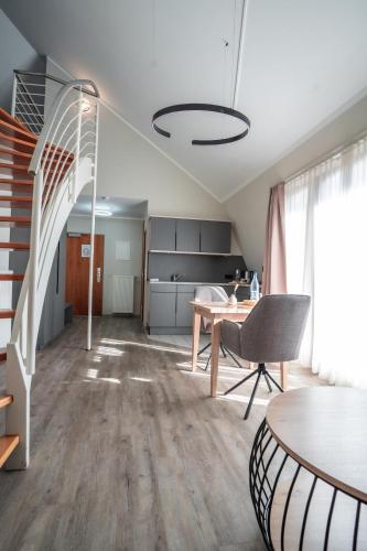 a living room with a staircase and a table at Hotel CityHome am Kurpark in Bad Salzuflen