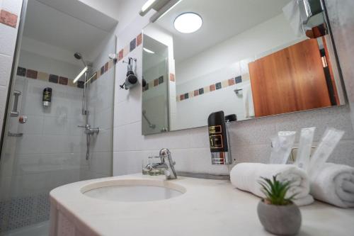 a bathroom with a sink and a mirror at Hotel CityHome am Kurpark in Bad Salzuflen
