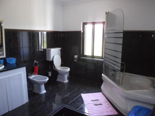 La salle de bains est pourvue de toilettes, d'une baignoire et d'un lavabo. dans l'établissement Albergue Constantino AL, à Paredes de Coura